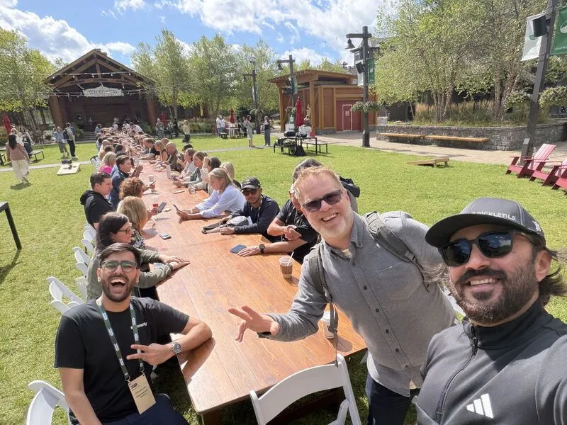 Moby taking a selfie at a long outdoor table
